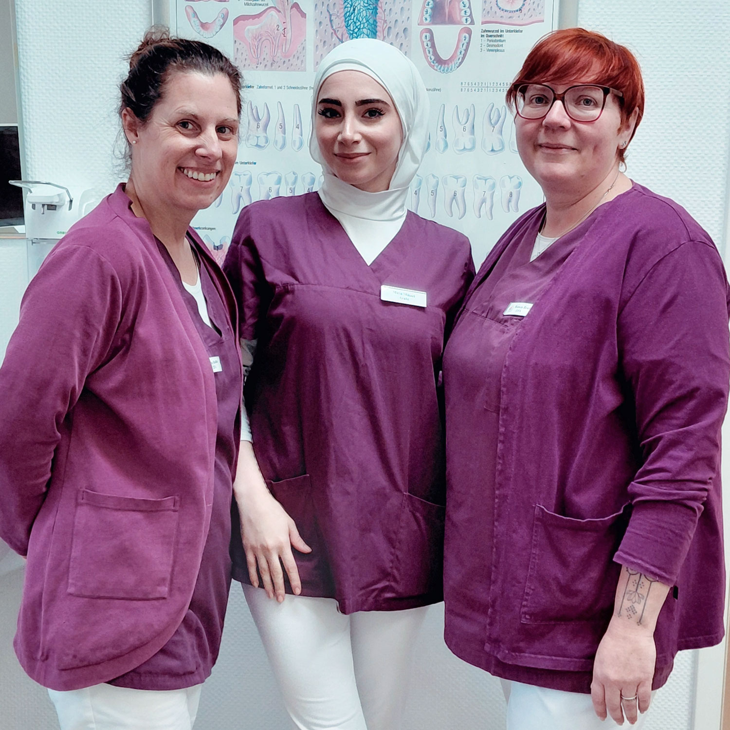 drei Zahnmedizinische Fachangestellte mit lila Kleidung